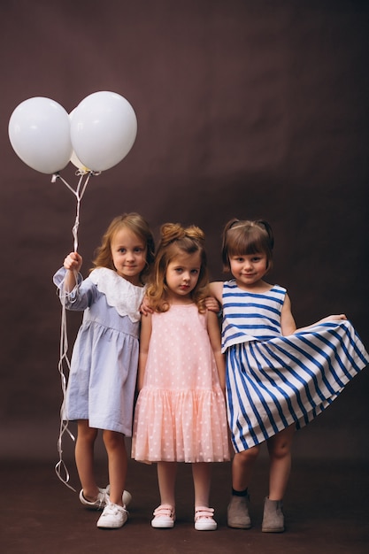 Three little girls models studio with balloons