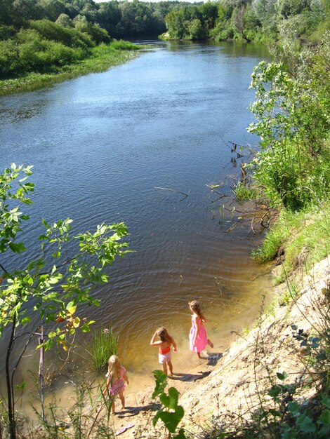 Three little girls plays at the river