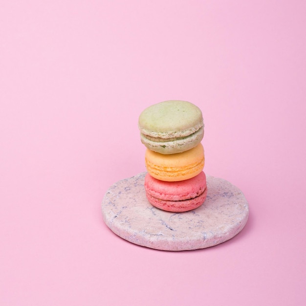 three macarons standing with pink background