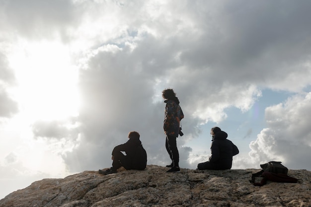 写真 スペインの曇りの日に山の頂上で美しい景色を楽しんでいる3人の男性のハイキングの友人