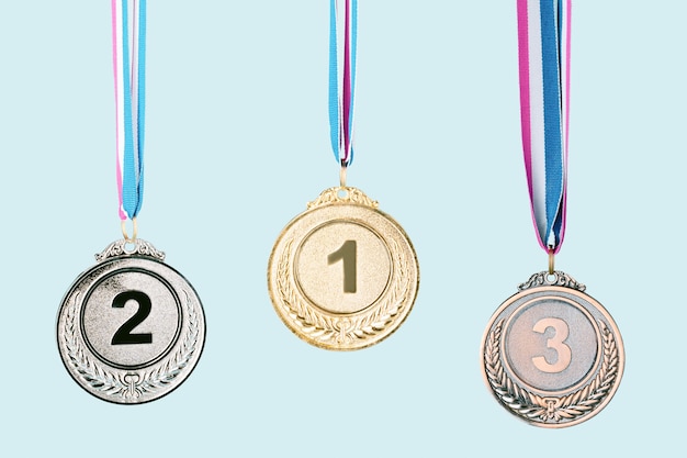 Фото Три медали (золото, серебро, бронза) на синем фоне. концепция награды и победы. место для копирования