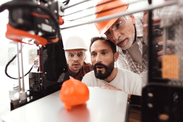 Foto tre uomini stanno lavorando per preparare il modello stampato