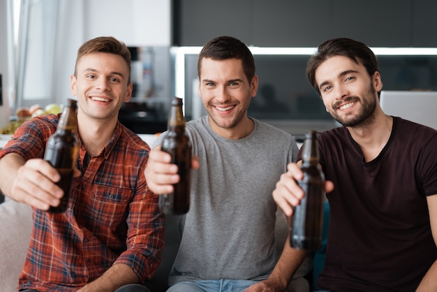 Трое мужчин пьют пиво. Ребята счастливы вместе.