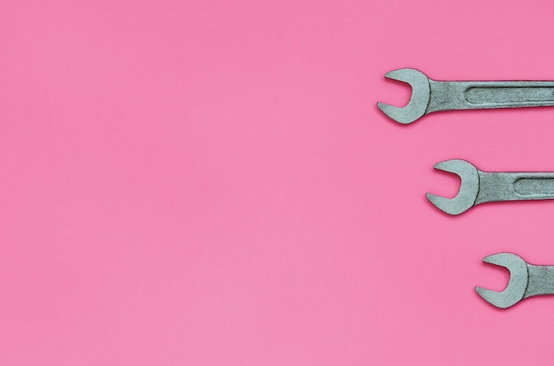 Three metallic spanners lie on texture background 