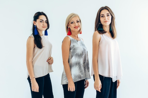 Three models blackhaired girls with earrings and an adult woman in tshirts and jeans