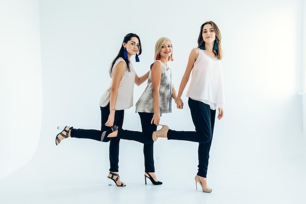 Three models blackhaired girls with earrings and an adult woman in tshirts and jeans