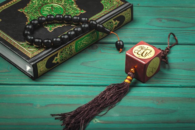 Photo three months islamic holy book quran with rosary beads ramadan concept