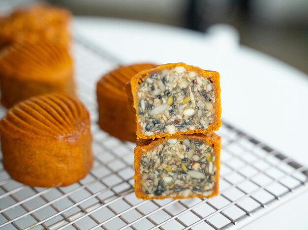 Photo three muffins on a cooling rack with one being cut up