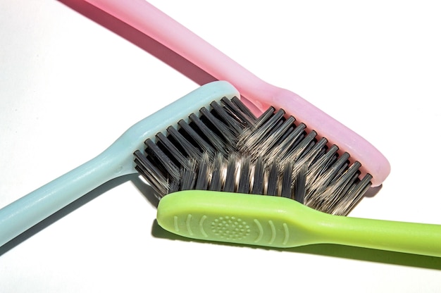 Three multi-colored toothbrushes on a white background.