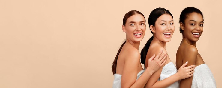 Photo three multiracial women posing in bath towels white background panorama