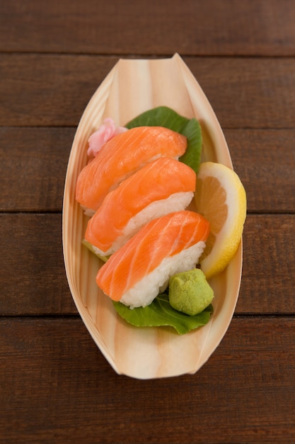 Three nigiri sushi served in wooden boat plate