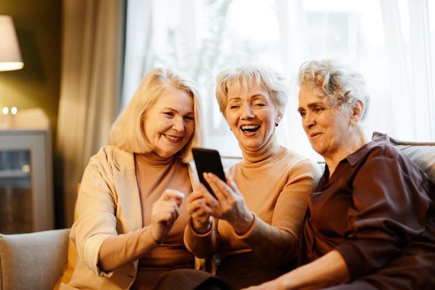 Three old women using mobile phone