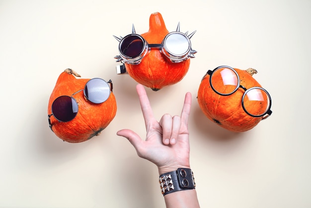 Three orange rocker pumpkins with glasses and a mustache on a light