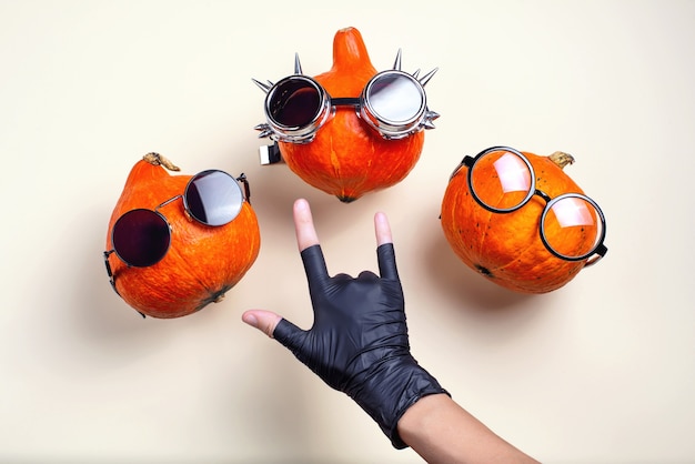 Three orange rocker pumpkins with glasses and a mustache on a light