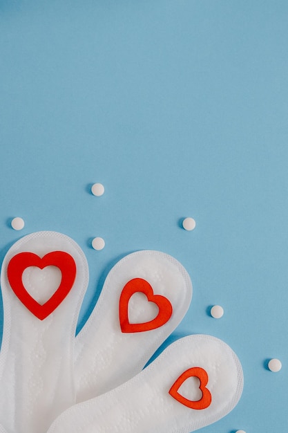 Three pads with hearts and pills on a light blue background