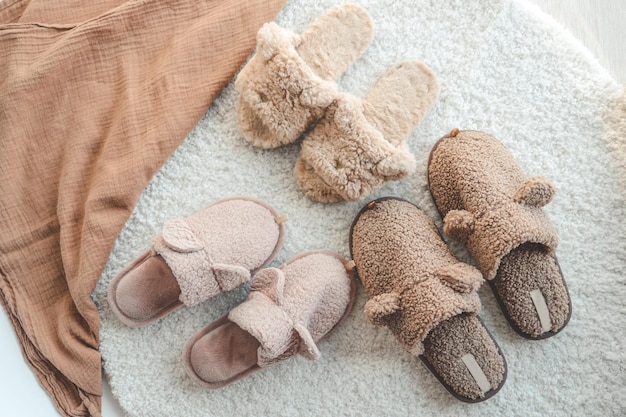 Three pairs of slippers on the carpet from above