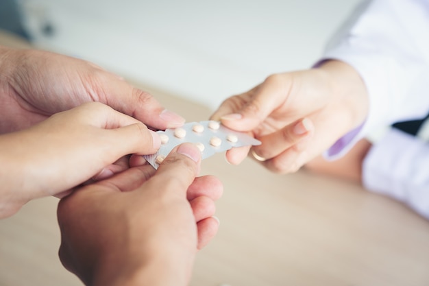 Three patients struggle for medicine from the doctor