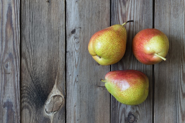 Three pears on a natural wooden table. Copy space