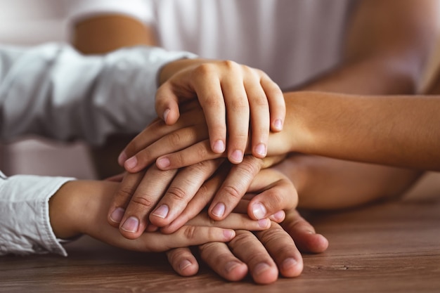 Photo the three people hold hands together at the table