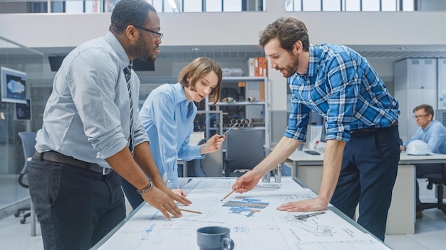 Photo three people looking at a blueprint on a table