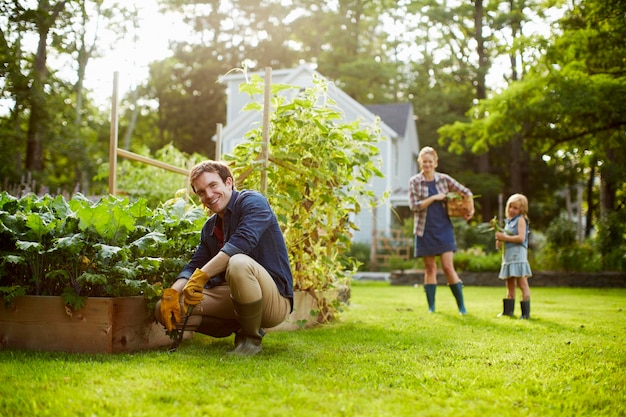 Three people two adults and a child in a vegetable garden