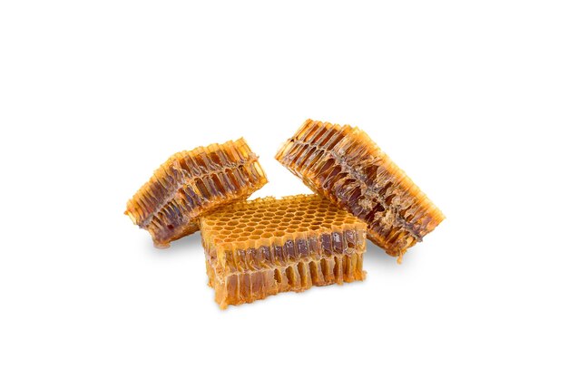 three pieces of beeswax with honey on a white background