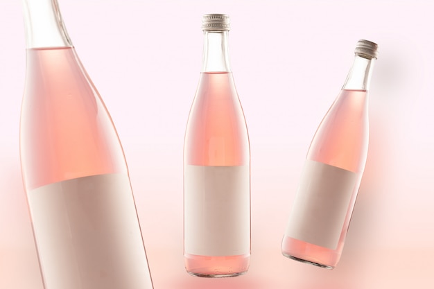 Photo three pink bottles of mockup-cola drinks, wine or beer. empty white labels