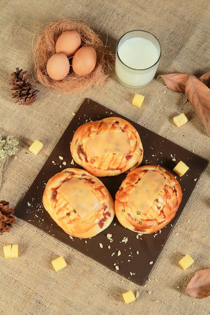 Three pizzas with cheese on top and a glass of milk on the side.