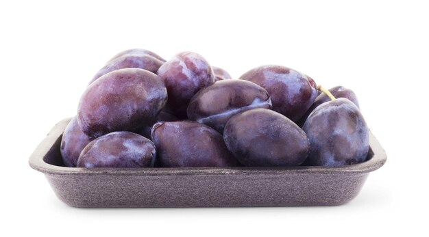 Photo three plums with leaves on white background