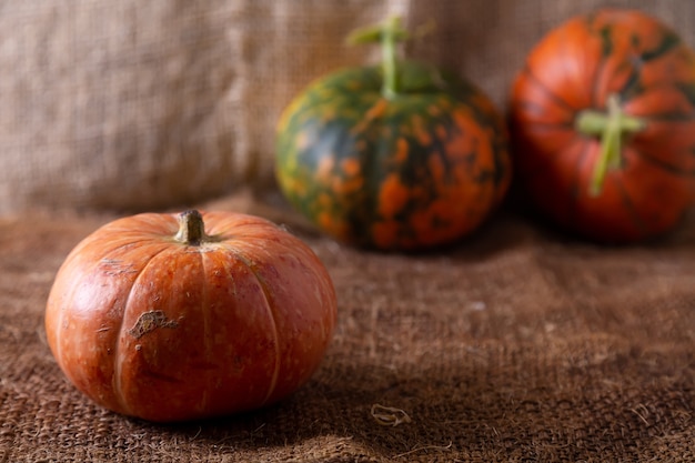 Three pumpkins on burlap.