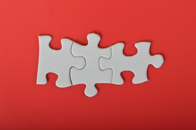 Three puzzle pieces isolated on a red background