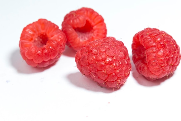 Three raspberries on a white background