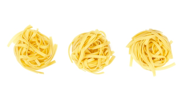 Photo three raw tagliatelle pasta nests in a row