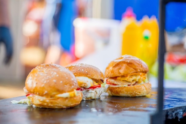 Three readymade appetizing tall burgers in a commercial kitchen Ready order