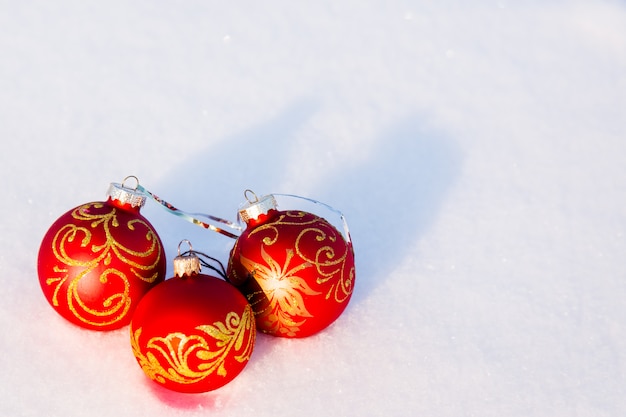 Three red christmas balls on a snow.