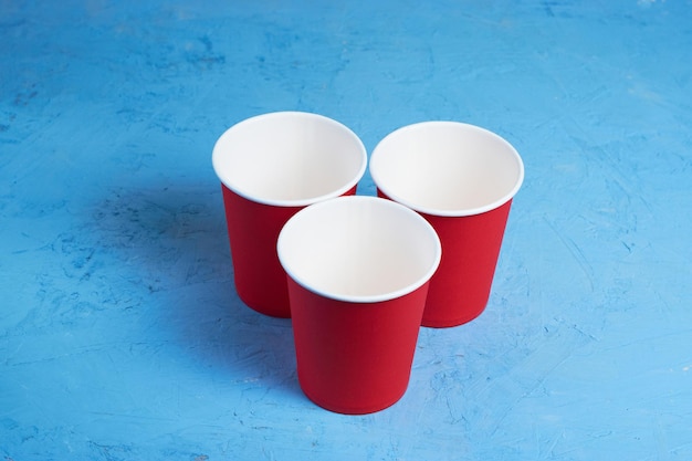 사진 파란색 배경 에 있는 세 개의 빨간색 일회용 컵