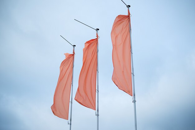 Photo three red flags in the blue sky flutter in the wind