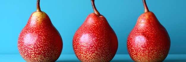 Three red pears with spots on them are lined up against a blue background ai