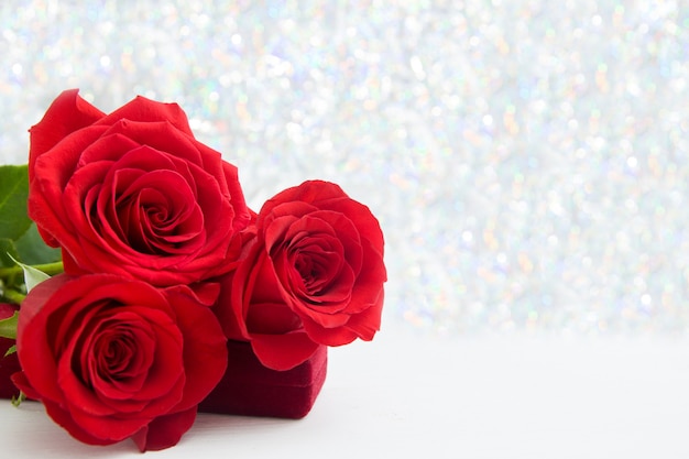 Three Red Roses and jewelery present box with boke Background