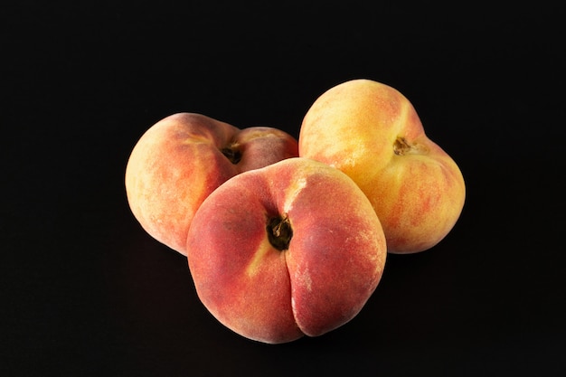 Three ripe fig peaches  on black background