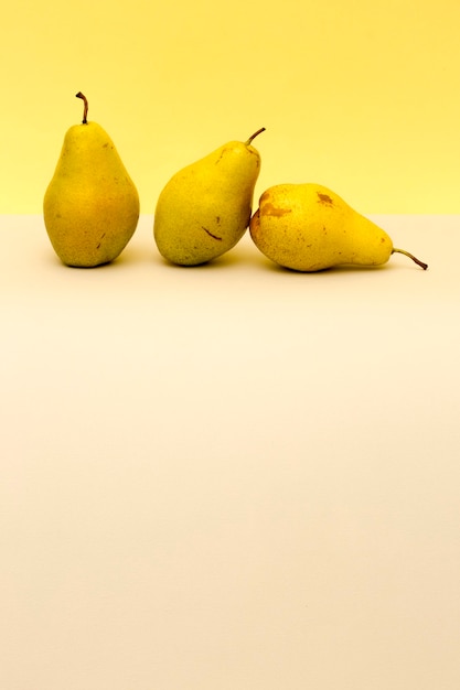 Three ripe pears on a colored background