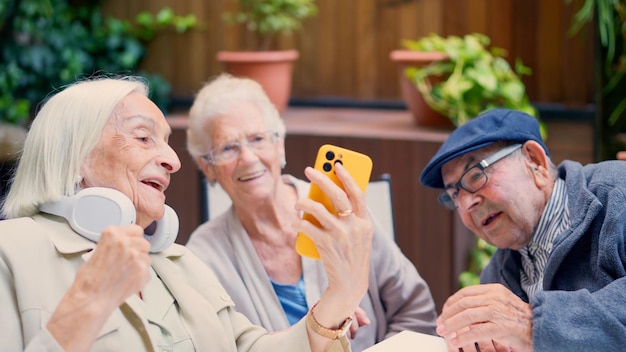 Three senior people of a geriatric using phone and smiling