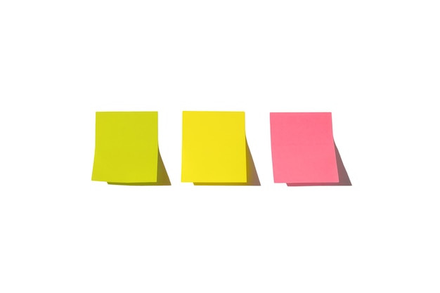 Foto tre fogli di carta per appunti, pronti per il tuo messaggio. note adesive isolate su priorità bassa bianca. colori rosa, verde e giallo. copia spazio.