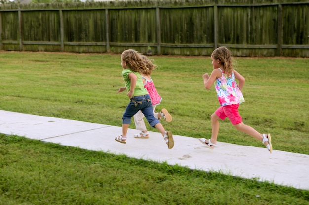 Three sister girls playing running on the park