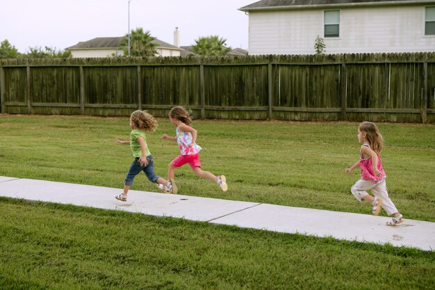 Photo three sister girls playing running on the park