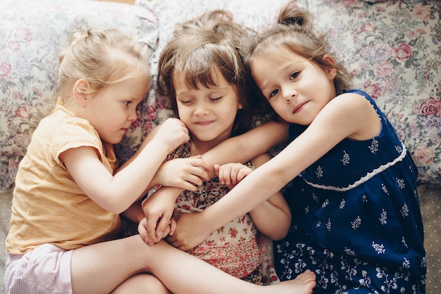 Foto tre sorelle giacciono fianco a fianco sul letto