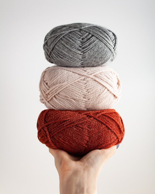 Three skeins of yarn in hand Nice photo for a hobby vertical orientation Hobby aesthetics