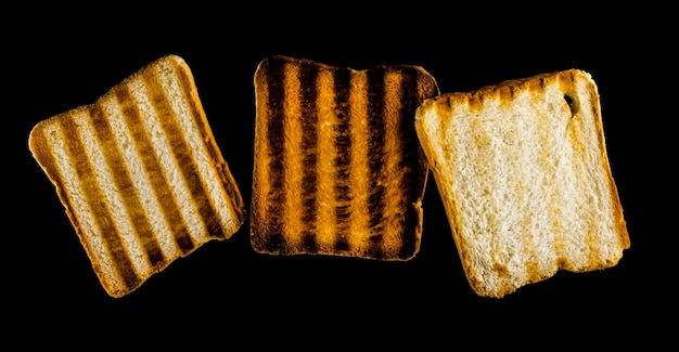 Three slices of toasted bread on the grill on a black background Toast bread