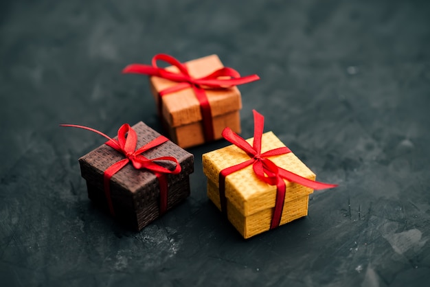 Three small gift boxes on dark background.