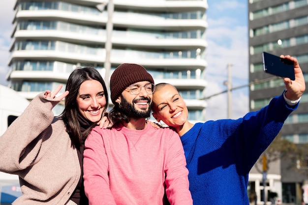 Three smiling friends taking a selfie in the city